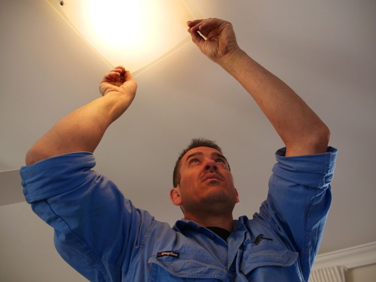 Electrician completing a ceiling light installation and lighting repair in a Brisbane home